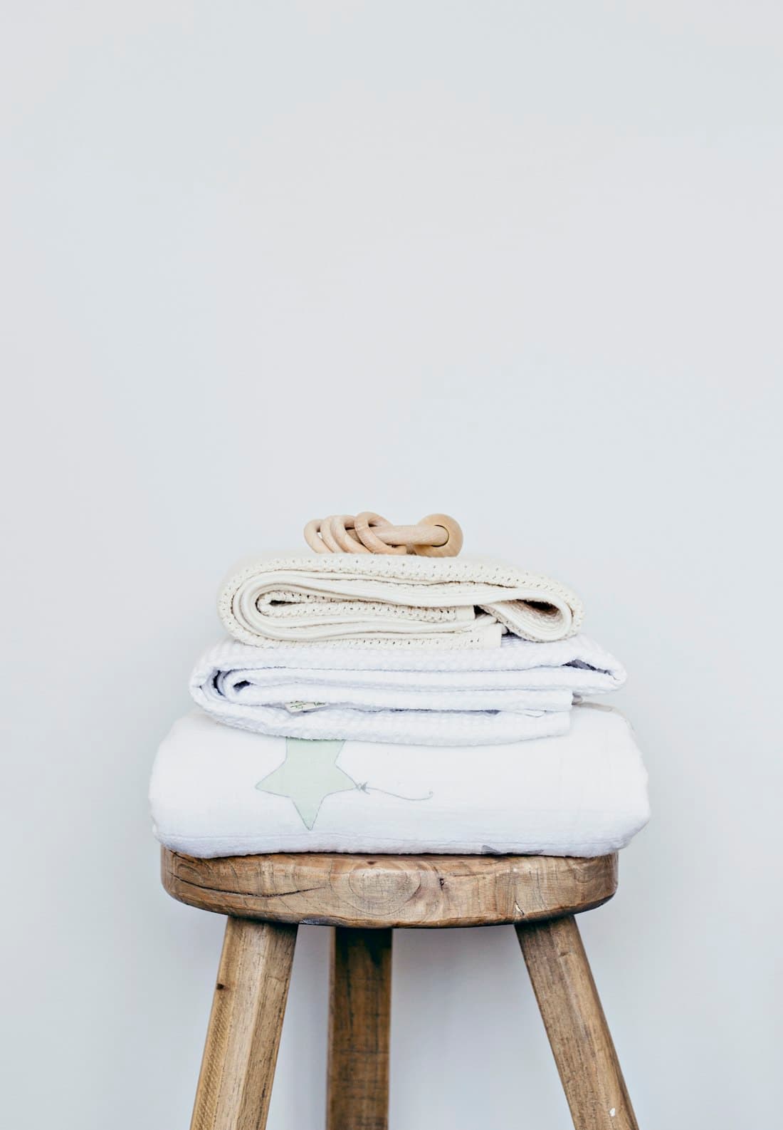 Pressed linens folded on a wooden stool
